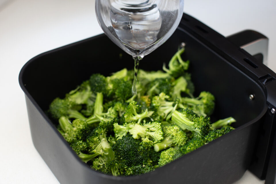 Pouring water into an air fryer base.