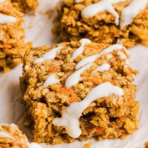 These EASY Healthy Carrot Cake Oatmeal Breakfast Bars make a quick on-the-go breakfast, snack or wholesome dessert! Made with zero refined sugar and drizzled with a delicious maple cream cheese frosting.