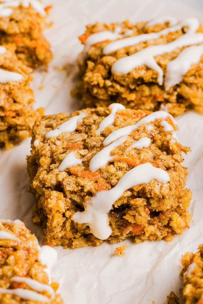 These EASY Healthy Carrot Cake Oatmeal Breakfast Bars make a quick on-the-go breakfast, snack or wholesome dessert! Made with zero refined sugar and drizzled with a delicious maple cream cheese frosting.