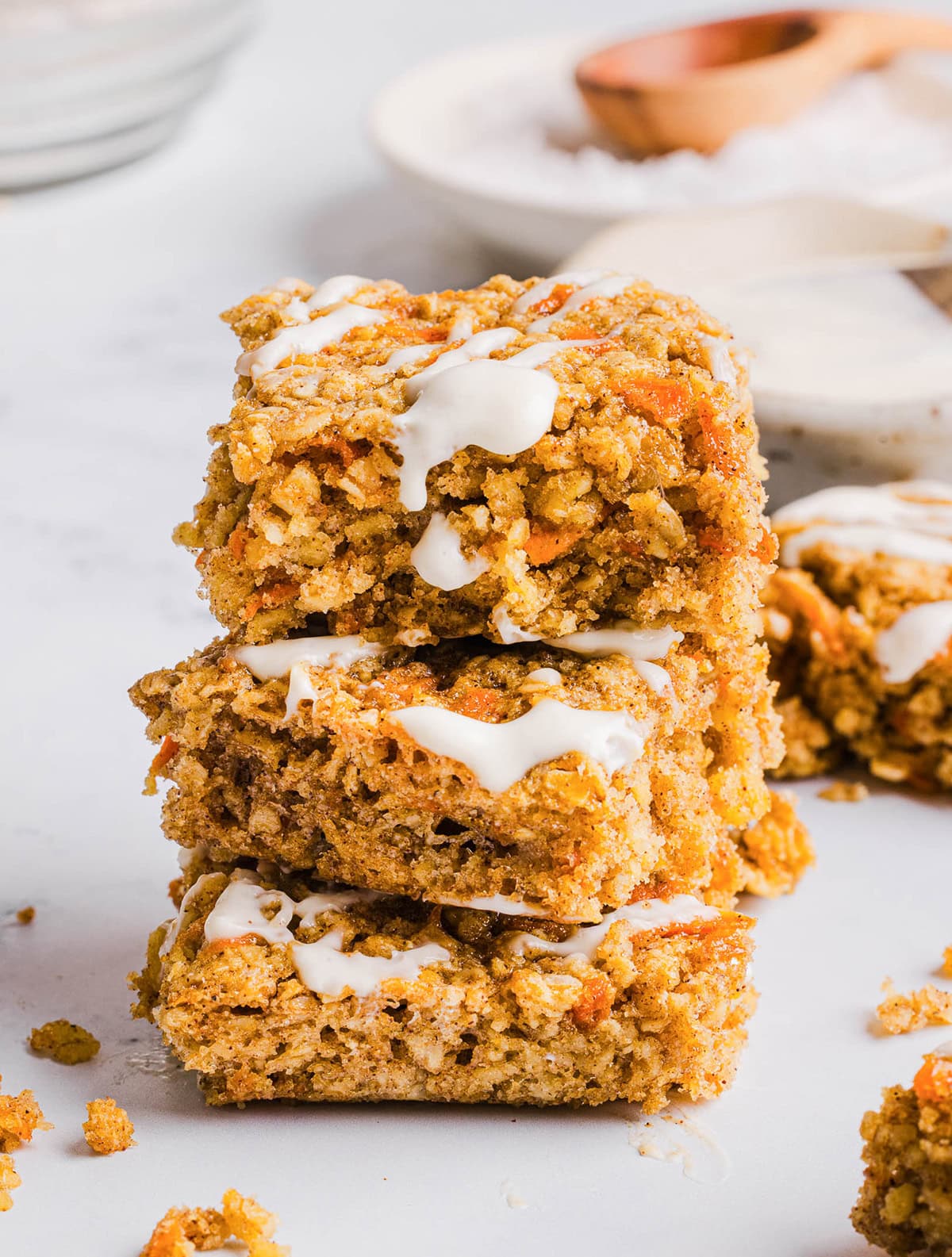 These EASY Healthy Carrot Cake Oatmeal Breakfast Bars make a quick on-the-go breakfast, snack or wholesome dessert! Made with zero refined sugar and drizzled with a delicious maple cream cheese frosting.