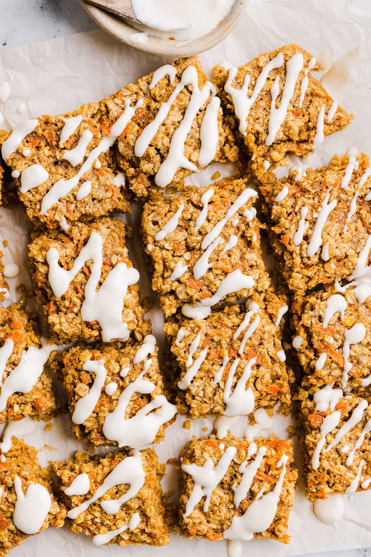 These EASY Healthy Carrot Cake Oatmeal Breakfast Bars make a quick on-the-go breakfast, snack or wholesome dessert! Made with zero refined sugar and drizzled with a delicious maple cream cheese frosting.