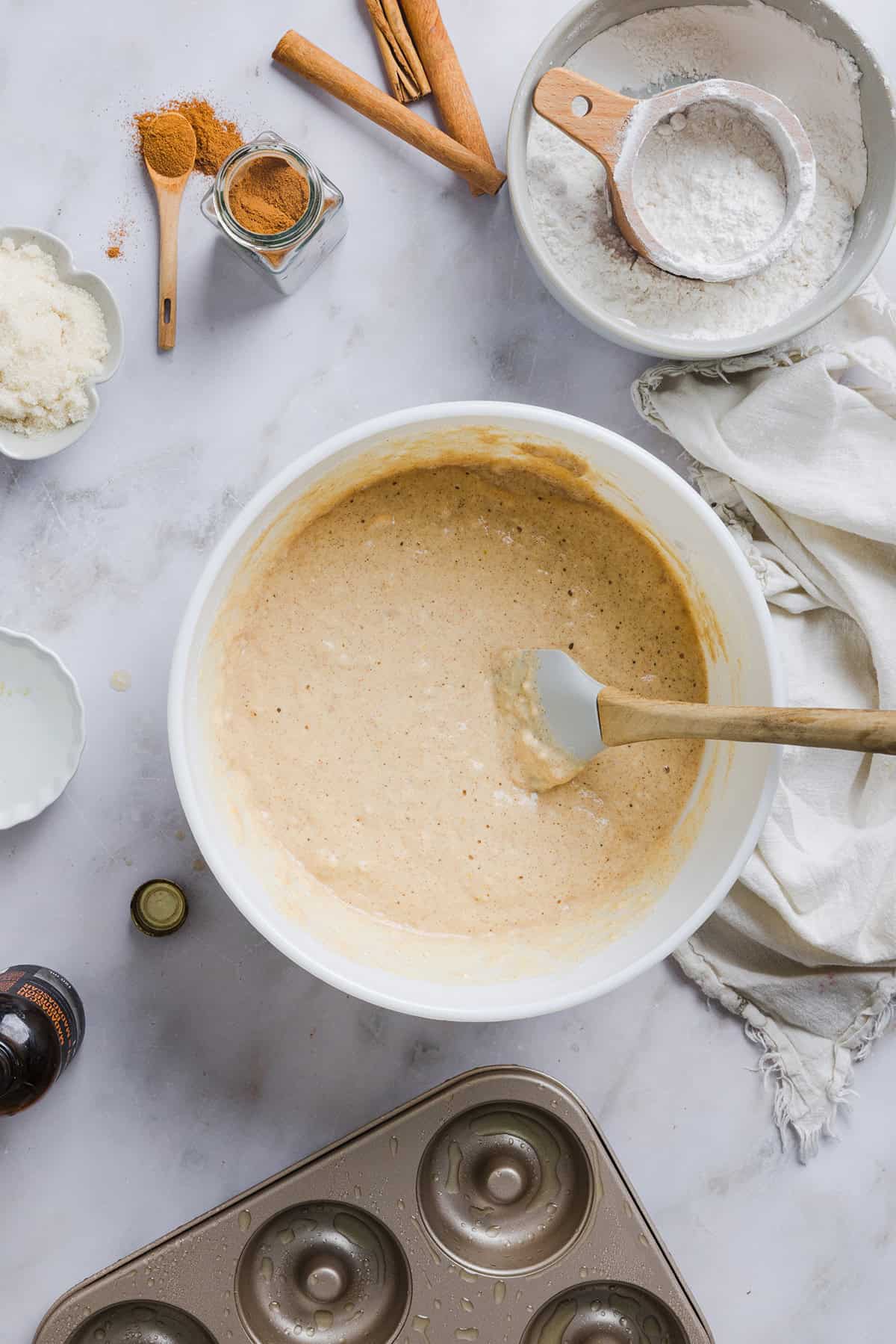 Soft Baked Apple Cider Donuts made healthier with whole wheat flour, applesauce and Greek yogurt for the perfect fall treat that comes together in just 20 minutes! Loaded with warm spices and coated with cinnamon and sugar!