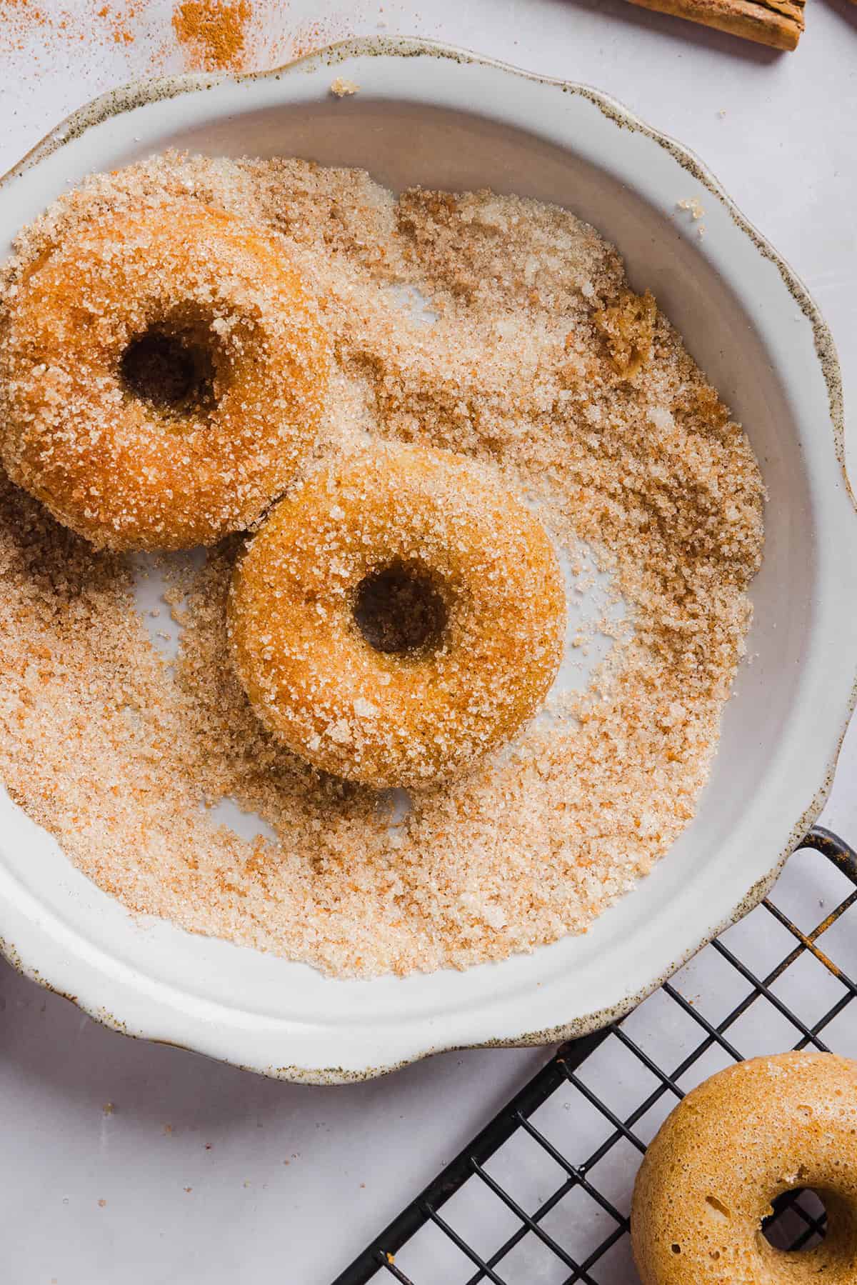 Soft Baked Apple Cider Donuts made healthier with whole wheat flour, applesauce and Greek yogurt for the perfect fall treat that comes together in just 20 minutes! Loaded with warm spices and coated with cinnamon and sugar!