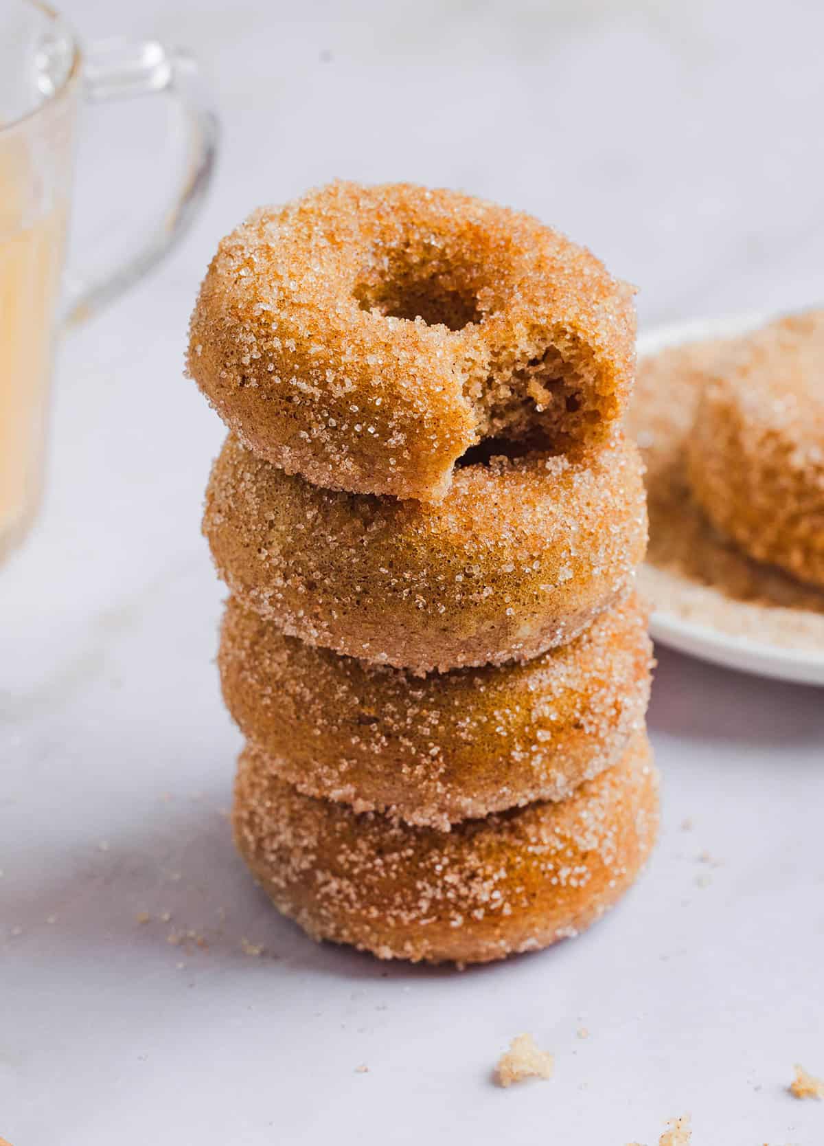 Soft Baked Apple Cider Donuts made healthier with whole wheat flour, applesauce and Greek yogurt for the perfect fall treat that comes together in just 20 minutes! Loaded with warm spices and coated with cinnamon and sugar!