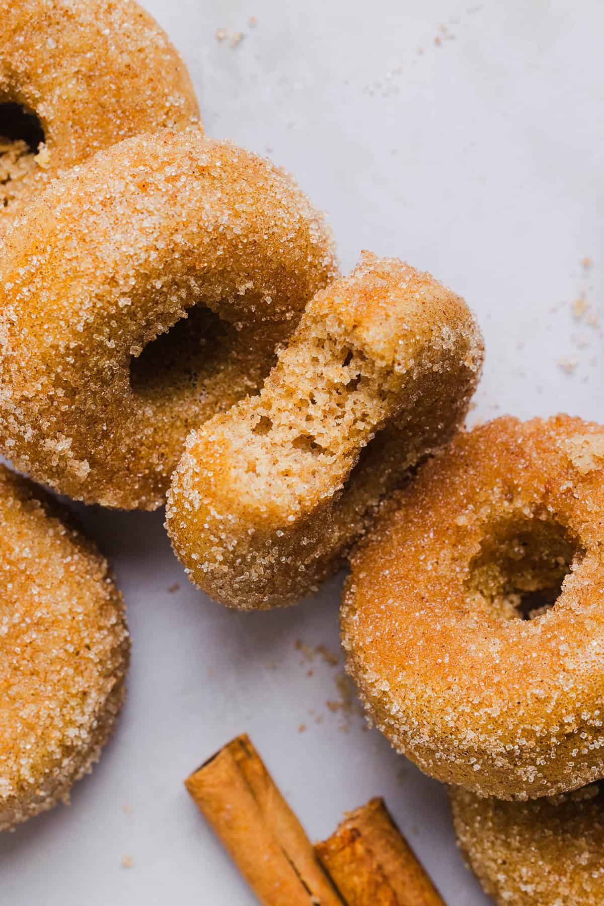 Soft Baked Apple Cider Donuts made healthier with whole wheat flour, applesauce and Greek yogurt for the perfect fall treat that comes together in just 20 minutes! Loaded with warm spices and coated with cinnamon and sugar!