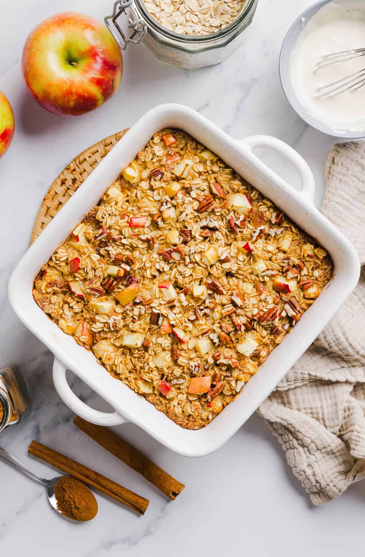 This Apple Cinnamon Baked Oatmeal is a cozy breakfast made with wholesome oats, shredded apples, and warm spices while naturally sweetened with maple syrup and plump raisins! We also topped this with crunchy pecans and a delicious maple cream cheese glaze!